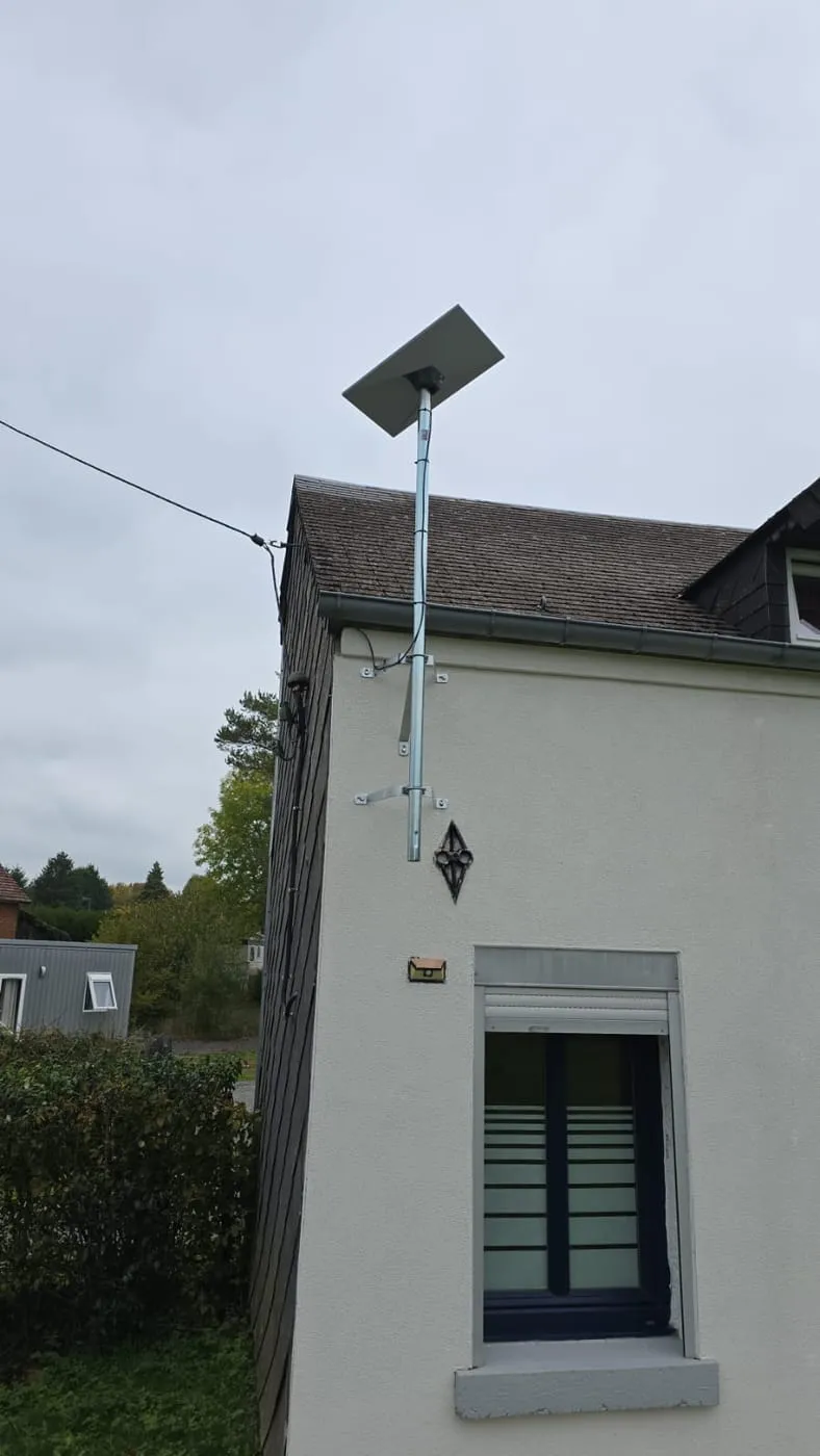 Antenne Starlink sur mât, maison blanche