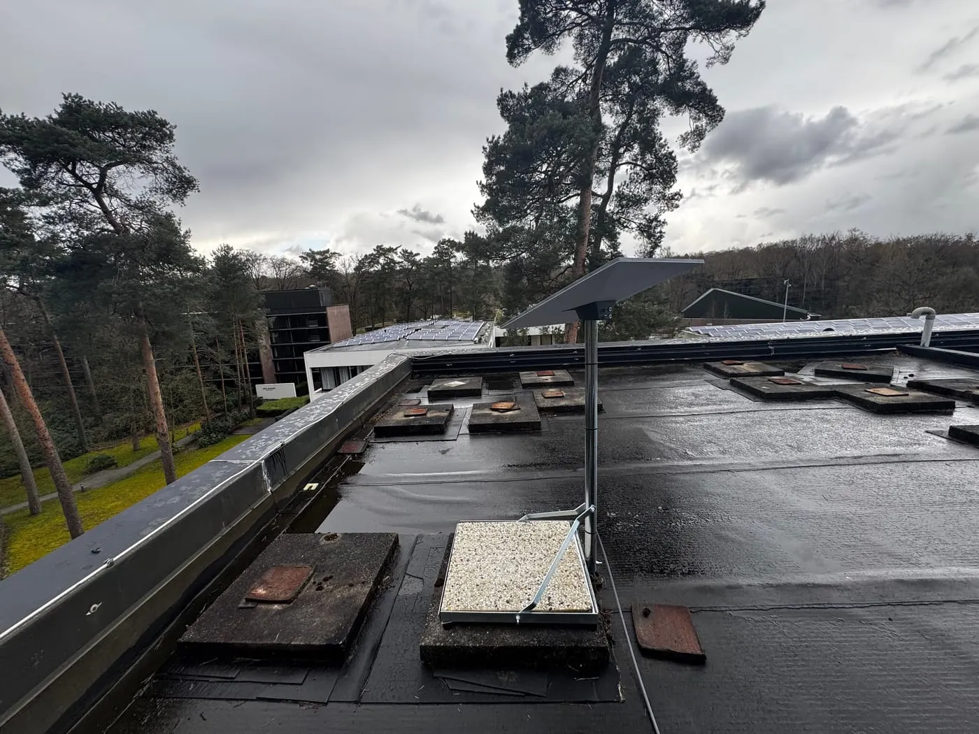 Antenne Starlink sur pied lesté, posée sur le toit plat d'un bâtiment