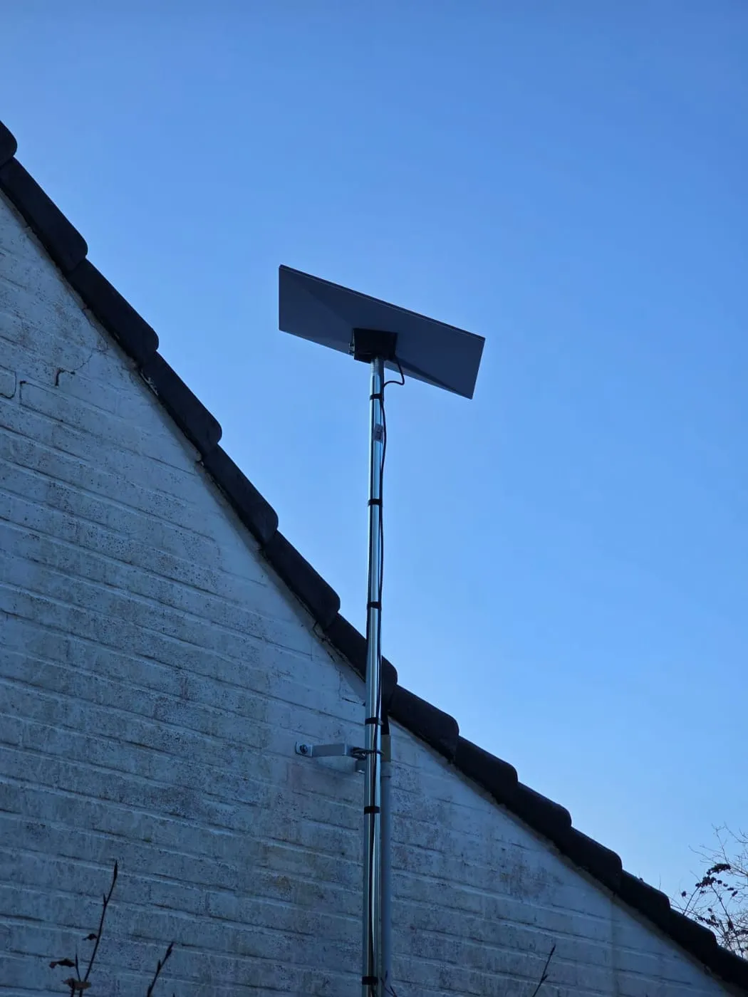 Antenne Starlink sur mât, ciel bleu