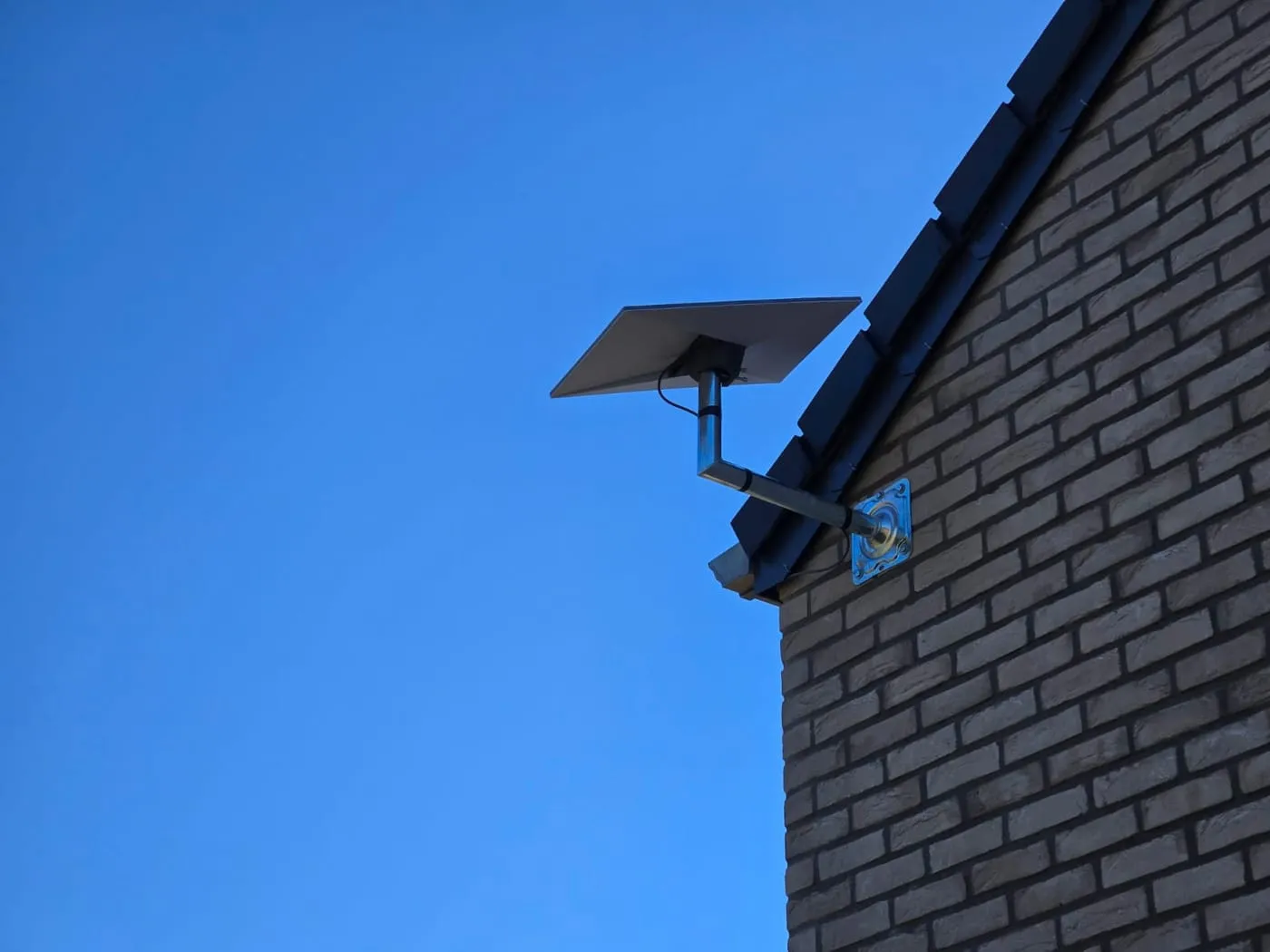 Antenne Starlink sur support mural, ciel bleu