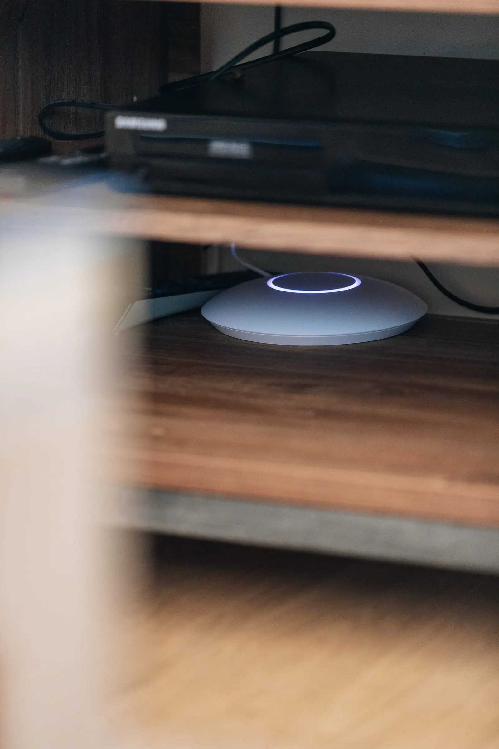 Borne Wi-Fi UniFi posée dans un meuble, anneau lumineux bleu allumé