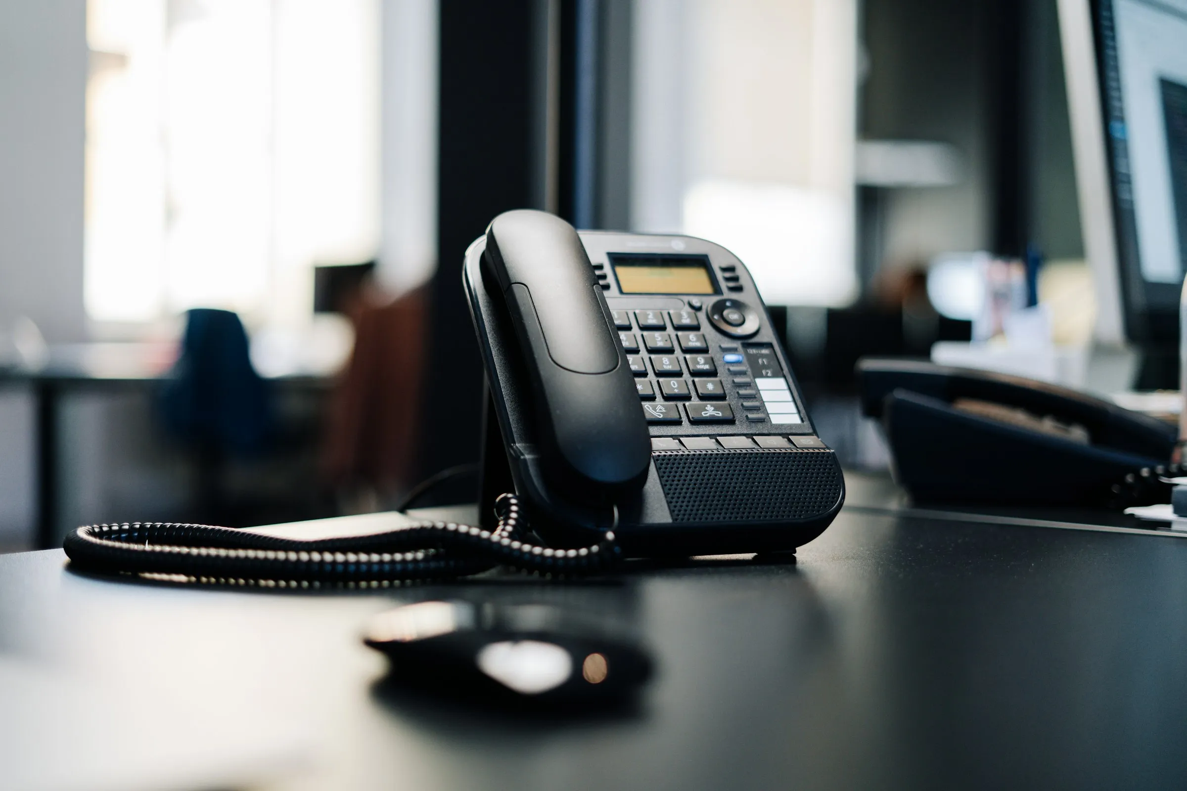 Téléphone IP posé sur un bureau, dans un espace de travail