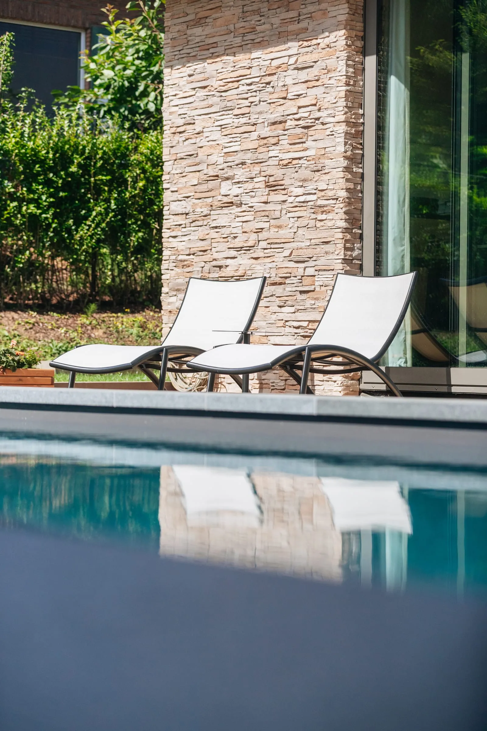 Terrasse et piscine d’une maison, deux transats au soleil