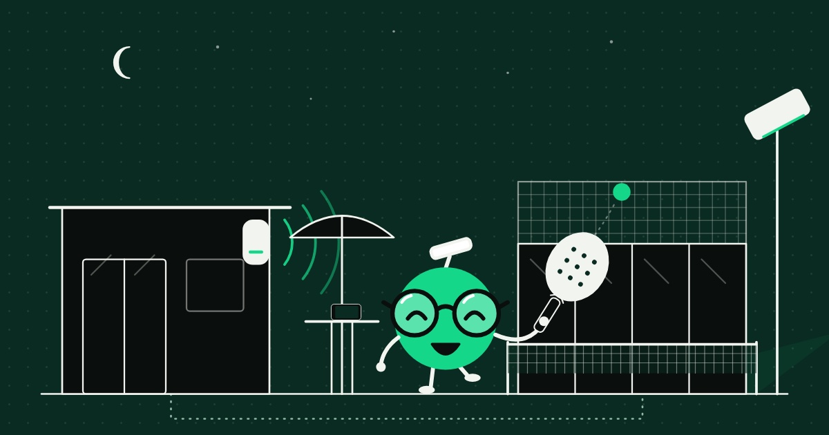 Le soir au club, la mascotte de SateLink tient une raquette de padel entre la terrasse, couverte par une borne Wi-Fi posée sur la façade du club-house, et le terrain éclairé, relié au club-house par un câble enterré.